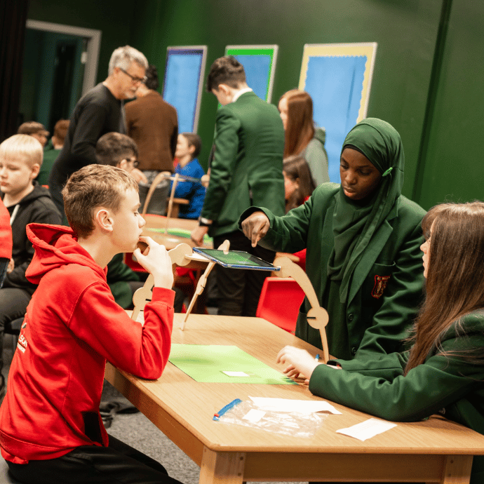 A group of children at a table in a classroom creating a stop-motion animation together.