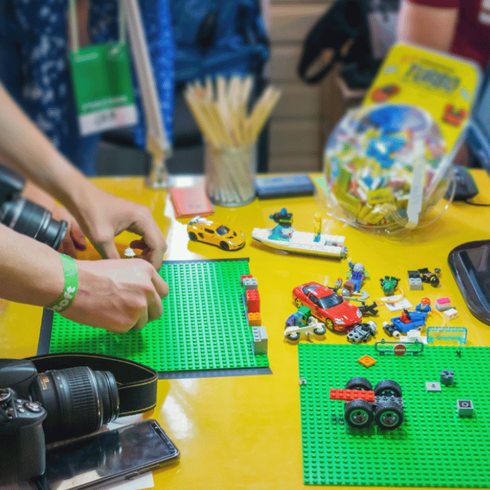 A group of people are creating a stop-motion animation with building blocks.
